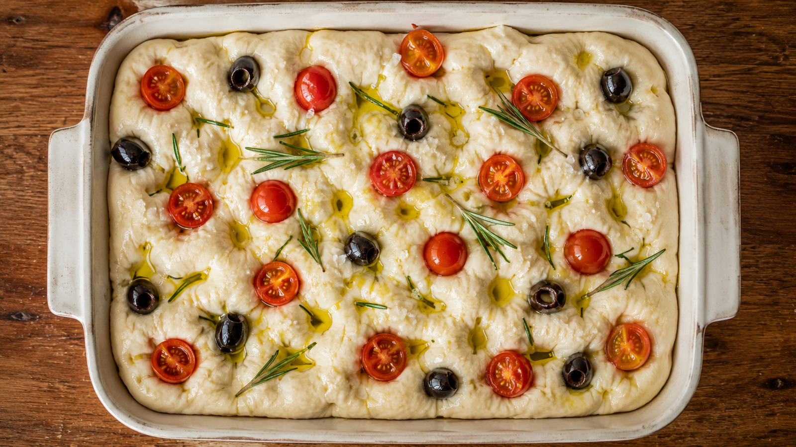 Focaccia s dolíčky, rozmarýnem a cherry rajčaty před pečením